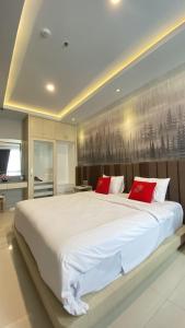 LaweanSolo Grand City的卧室配有带红色枕头的大型白色床