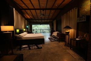 康提Aayu Hanthana Boutique Hotel的一间卧室配有一张床、一张沙发和一个窗口