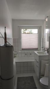 罗斯托克Wohnung Meeresbrise 48 qm mit Balkon的带浴缸、水槽和窗户的浴室