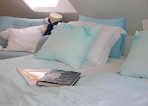 Kiemeliai薰衣草村酒店的一本书坐在床上,上面有枕头