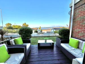 本莱赫Apartment 3 Benllech with Sea views的平台上设有带沙发和桌子的庭院