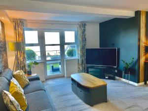 本莱赫Apartment 3 Benllech with Sea views的带沙发和平面电视的客厅