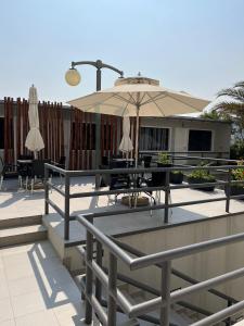 罗安达Casas de Luanda GH-Alvalade的户外庭院配有桌子和遮阳伞。