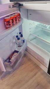 阿斯隆#6 TGHA Luxury Two Bedroom Apartment in Athlone的配有瓶装苏打水和饮料的开放式冰箱