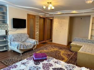 卡拉甘达Уютная квартира Н.Абдирова 32的带沙发和电视的客厅