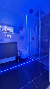 阿斯隆#6 TGHA Luxury Two Bedroom Apartment in Athlone的浴室设有卫生间和带蓝色灯光的淋浴。