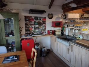 HankHoliday cottage de Garage Inn的厨房配有红色冰箱和桌子