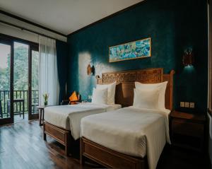 河内Amour Resort Bavi的绿墙客房的两张床