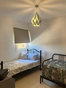 阿拉德Serene Oasis @ Arad的一间卧室配有一张床和一个吊灯