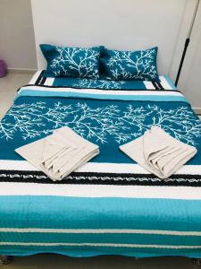 瓜拉丁加奴HOMESTAY CIK PHIA的蓝色的床,配有蓝色和白色的床单和枕头