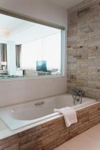 坤敬绿色度假酒店 的一间带大窗户和浴缸的浴室