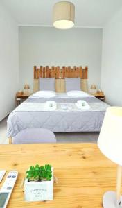 雅典Acropolis View Apartment in the Heart of Monastiraki的一间卧室配有一张床和一张带桌子的木桌。