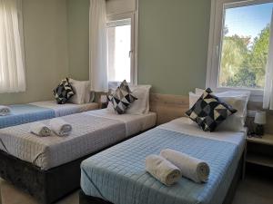 卡法斯Iris Studios Chios的一间卧室配有三张床和毛巾