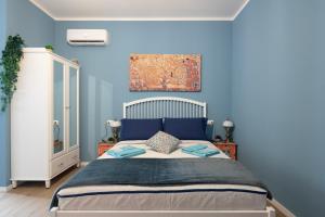 博洛尼亚CASA PETRONIO APARTMENTS BOLOGNA CENTER的一间卧室配有一张带蓝色墙壁的大床