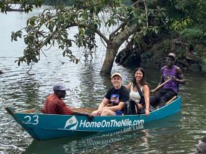 金贾Home On The Nile water front Cottage的一群人坐在蓝色的船上