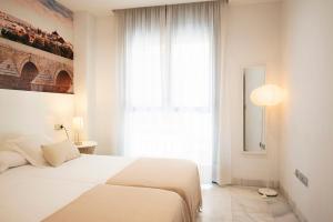 科尔多瓦科尔多瓦中心莫特瑞阿斯公寓的卧室设有白色的床和大窗户