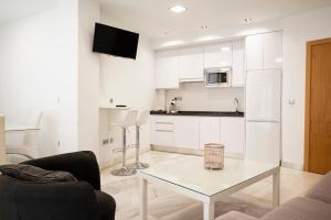 科尔多瓦科尔多瓦中心莫特瑞阿斯公寓的客厅设有带玻璃桌的白色厨房