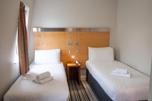 伦敦Maiden Oval的两张位于酒店客房的床,配有毛巾