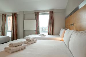 伦敦Maiden Oval的酒店客房,配有两张带毛巾的床