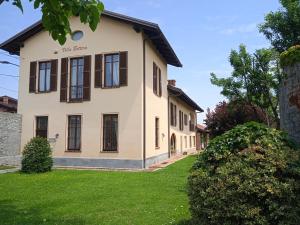 RiforanoVILLA BOTTERA with Jacuzzi in the garden Cuneo Langhe Piemonte的一间白色的房子,设有棕色的窗户和庭院