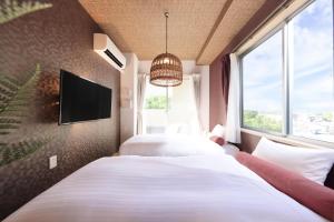 白滨阿卡利亚南新滨酒店的配有电视和窗户的客房内的两张床
