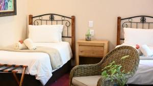 米德尔堡LUXURY FAMILY EN-SUITE ROOM @ 4 STAR GUEST HOUSE的酒店客房,配有两张床和椅子