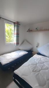 劳雷尔苏格MOBILHEIM HERZ LAUWERSOOG - Chalet Robbengat的带窗户的客房内的两张床
