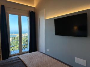 斯培西亚梅格利亚88酒店的一间卧室设有一张带电视的床和一个阳台。
