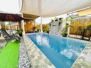 丹辘Kaha Briones Family Guest House的后院的游泳池,带遮阳伞