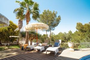 卡拉塔瑞达Oasis Living Can Nirvana - Best Sea Sunsets的一个带椅子和遮阳伞的甲板,棕榈树