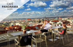 布拉格Wenceslas Square Hotel - Czech Leading Hotels的坐在建筑物屋顶桌子上的两名妇女