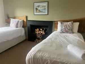 沙普New Ing Lodge的酒店客房设有两张床和壁炉