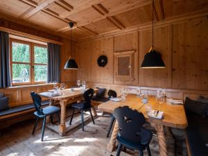 巴特维塞Berghotel Sonnenbichl的用餐室设有木墙和桌椅
