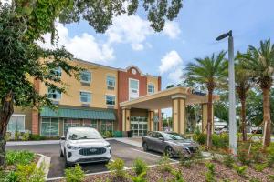 圣奥古斯丁Comfort Suites St Augustine Historic District Area的两辆汽车停在酒店门前的停车场