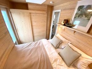 海利根港Hausboot Yara am Steg 1D的卧室配有一张床铺,位于带木墙的房间内