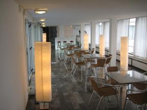 安德里亚Albergo dei Pini的用餐室配有桌椅和灯光