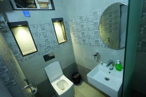 海得拉巴BIGSON SERVICE APARTMENTS MADHAPUR的一间带水槽、卫生间和镜子的浴室