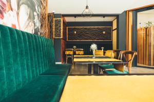 锡尼Hotel Alkar的一间带绿色沙发和桌子的用餐室
