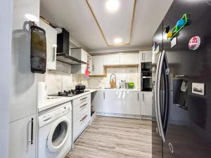 伦敦Spacious Double Bedroom in Shooters Hill的厨房配有白色橱柜和冰箱。