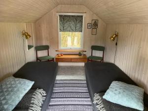 IdestrupStunning Romantic Cabin close to Baltic see的一间卧室设有两张床,窗户设有两把椅子