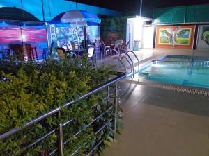 Bandhogarh FortTiger Heaven Resort的一个带桌子和遮阳伞的游泳池