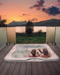 格伦科SeaBeds - Luxury Lookouts with Hot Tubs的两人在按摩浴缸内,享有湖景