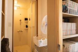 尾道市Bed&Cafe Onzo オンゾー的客房设有壁橱和架子上的风扇