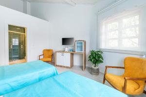 伯萨CASA MİSYA的一间卧室设有两张床、一台电视和一把椅子