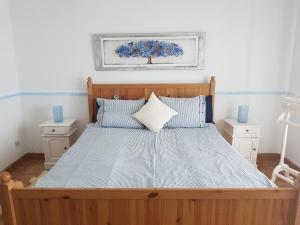Tejina de IsoraViVaTenerife - Retreat in nature, SPA and wellness的一间卧室配有一张带蓝色枕头的大型木制床。