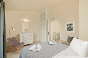 阿尔米罗斯海滩Skales Villas的白色卧室配有床和椅子