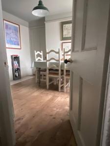 沙尔顿Quirky Victorian Cottage in Shaldon Devon的配有桌椅和门的房间