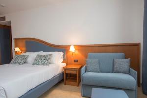 萨包迪亚Hotel Centrale的配有一张床和一把椅子的酒店客房