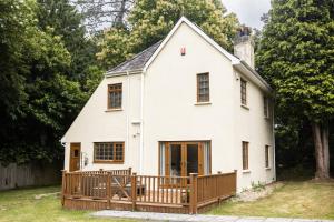 普里茅斯Romantic Cottage的白色的房屋,设有木甲板