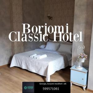 博尔若米Borjomi Classic Hotel的一张床位和床头柜的酒店标志